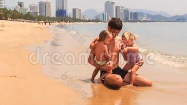 父亲在海边玩两个小女孩